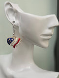Handmade American flag heart earring on a white mannequin ear, featuring navy blue enamel with gold stars, red and white enamel stripes, and a diagonal clear rhinestone band in a gold-tone setting
