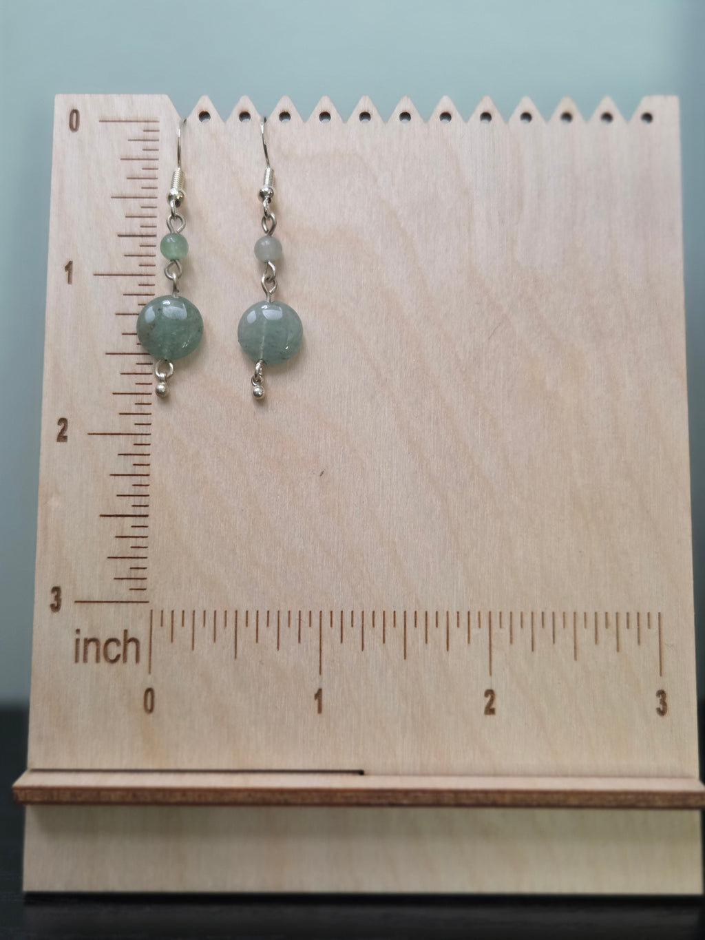 Aventurine dangle earrings displayed on a wooden earring stand with ruler showing approximately 1.75 inch length