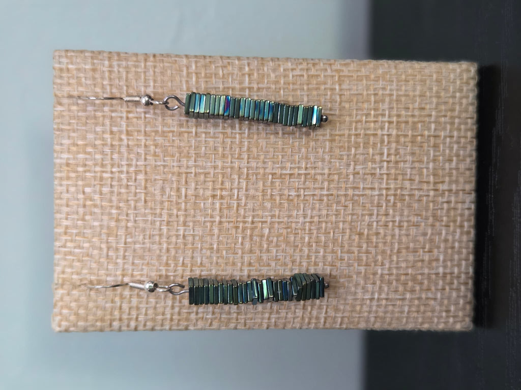 Close-up of Hemalyke square bead stack earrings with iridescent green-gold sheen
