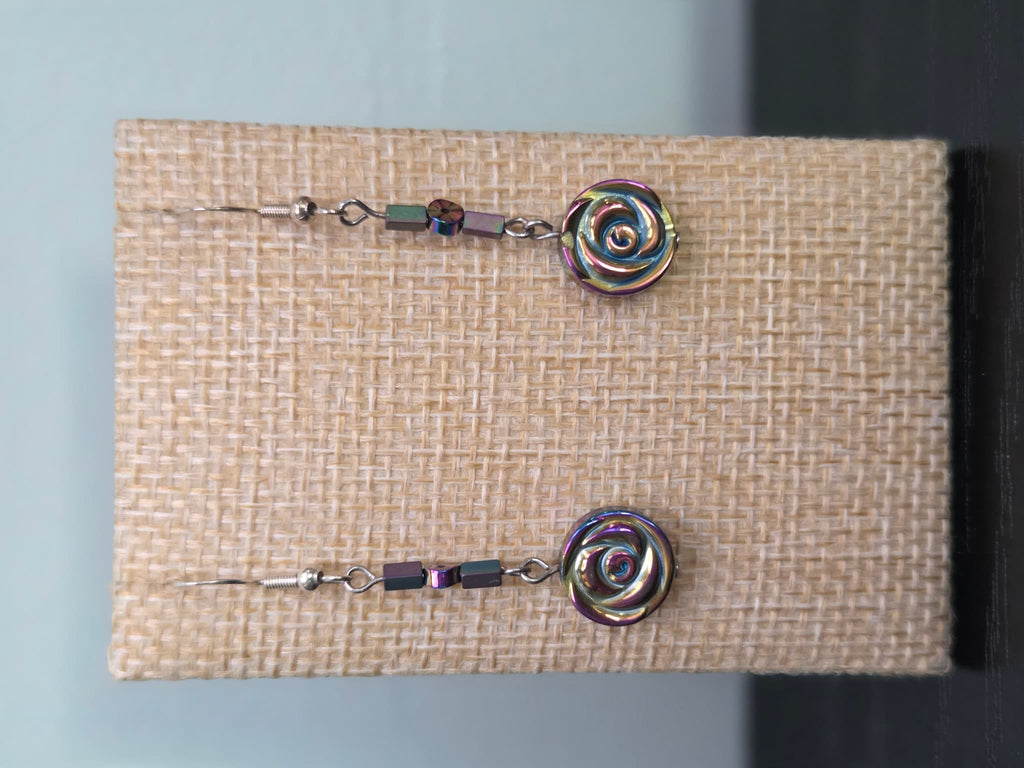 Close-up of carved Hemalyke rose bead earrings with iridescent rainbow sheen