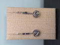 Close-up of carved Hemalyke rose bead earrings with iridescent rainbow sheen