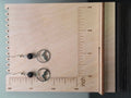 Mountain and lava stone drop earrings displayed on a wooden earring stand with ruler showing approximately 1.75 inch length