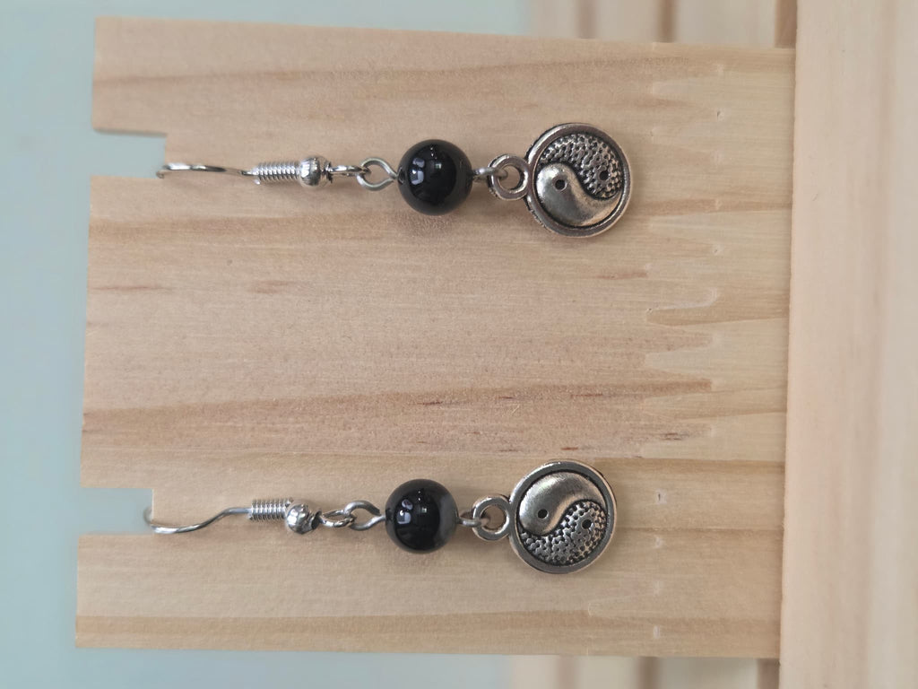 Black onyx beaded earring with silver-tone yin-yang charm on a fish hook ear wire