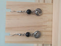 Black onyx beaded earring with silver-tone yin-yang charm on a fish hook ear wire