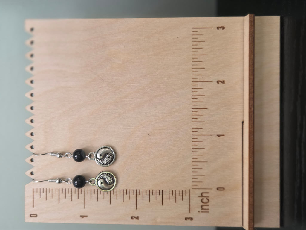 Pair of yin-yang onyx earrings shown beside a ruler, approximately 1.6 inches long
