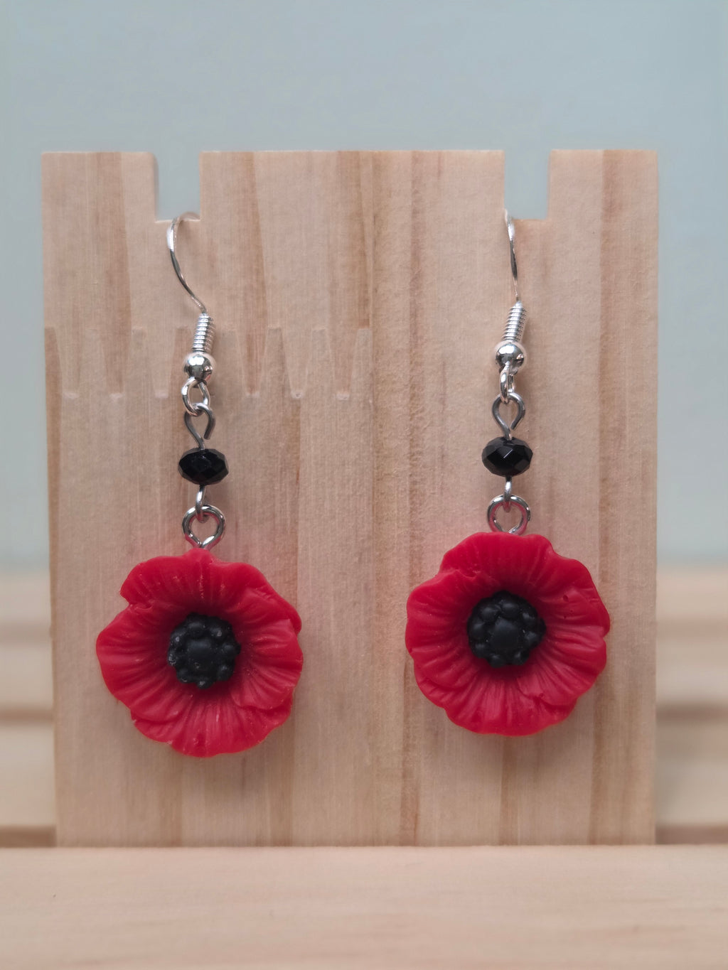 Red acrylic poppy flower dangle earrings with black glass bead accent and silver fish hook ear wires
