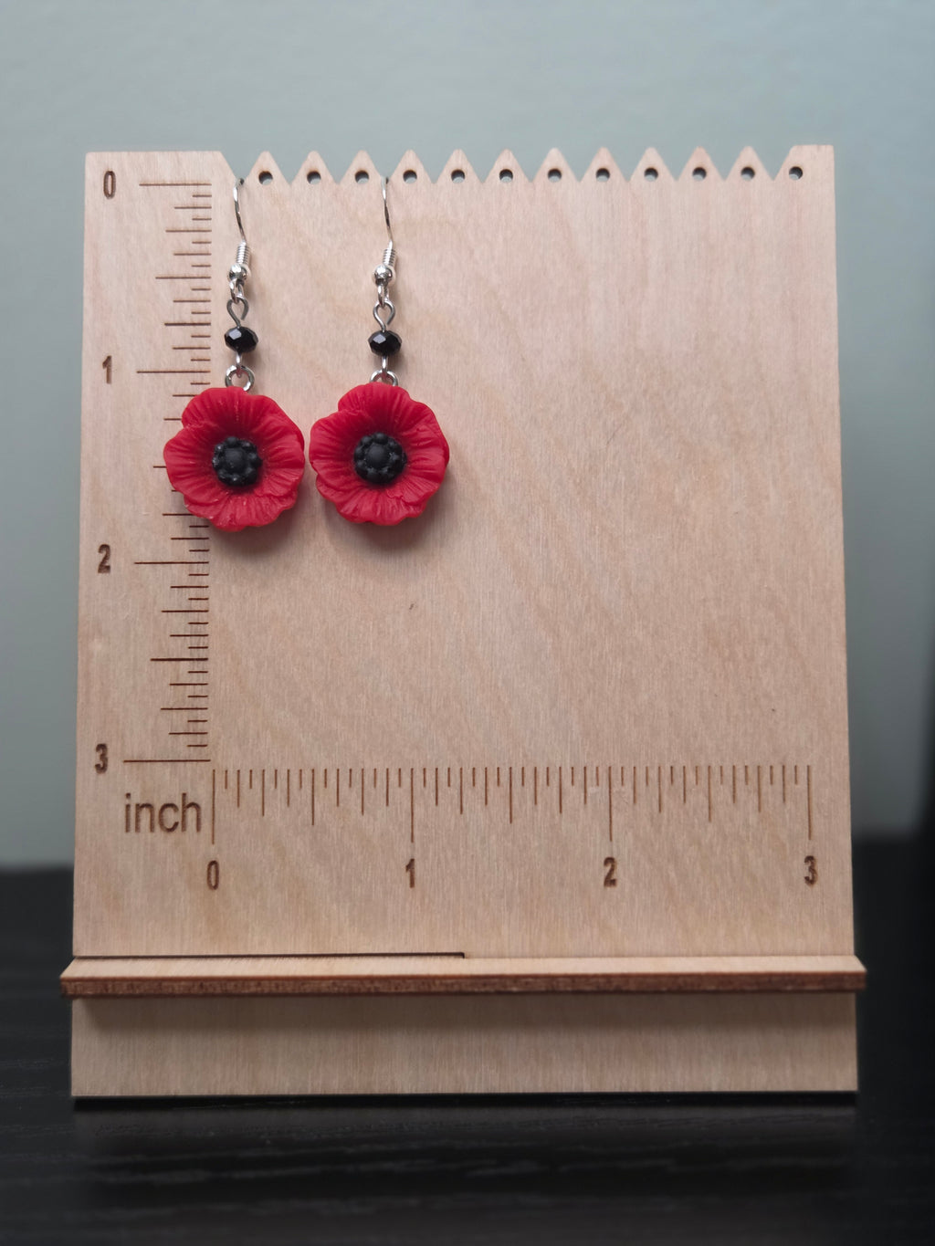 Red poppy flower earrings shown beside a ruler, approximately 1.6 inches long