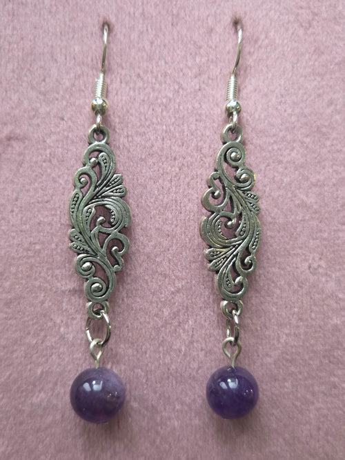 Pair of filigree amethyst drop earrings displayed on wooden ruler board showing approximately 2.25 inch length