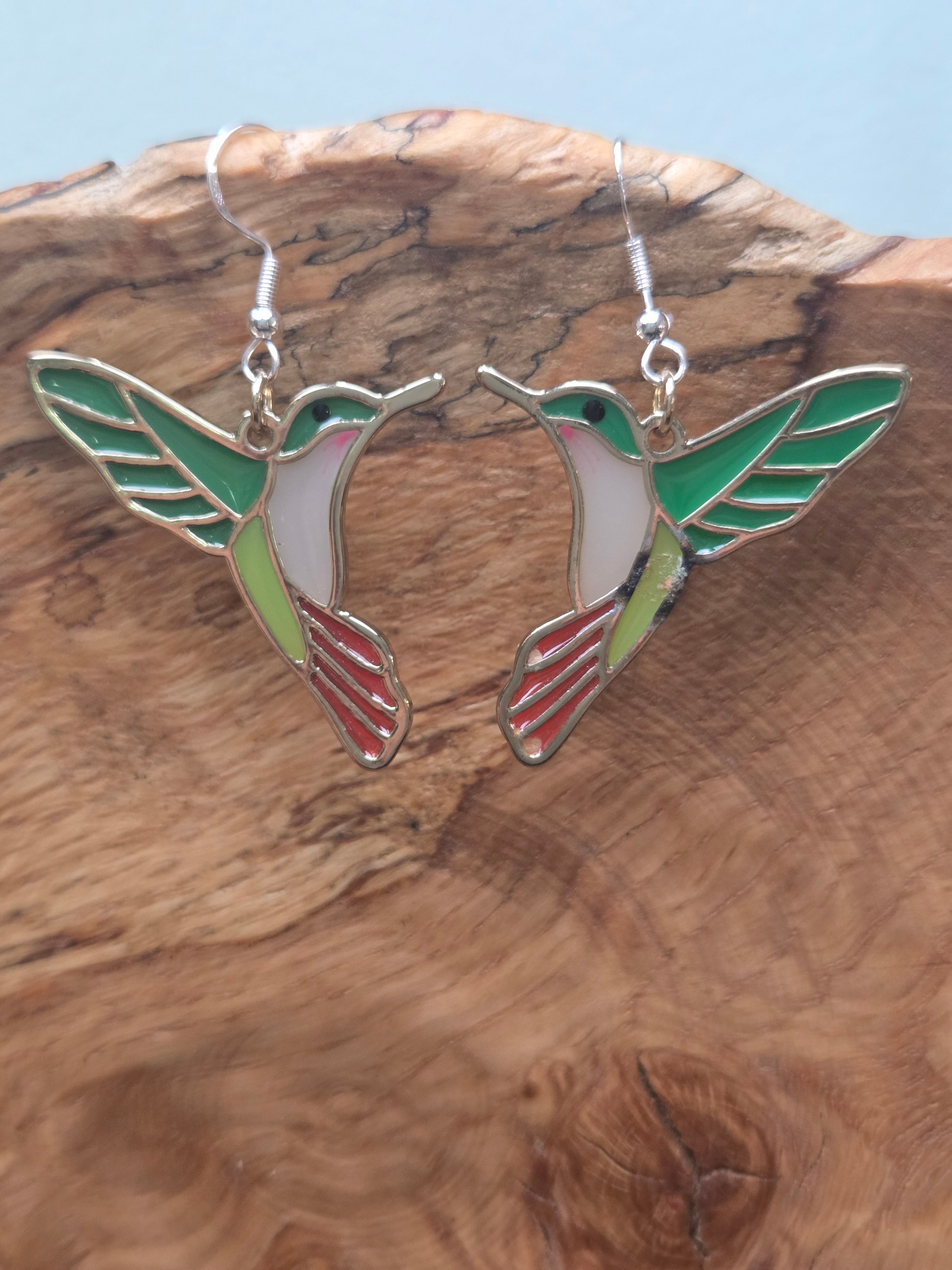 Stained glass style acrylic hummingbird dangle earrings in green, white, and red, gold-tone setting