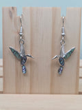 Abalone-style acrylic inlay hummingbird dangle earrings against ruler showing approximately 1 inch charm length