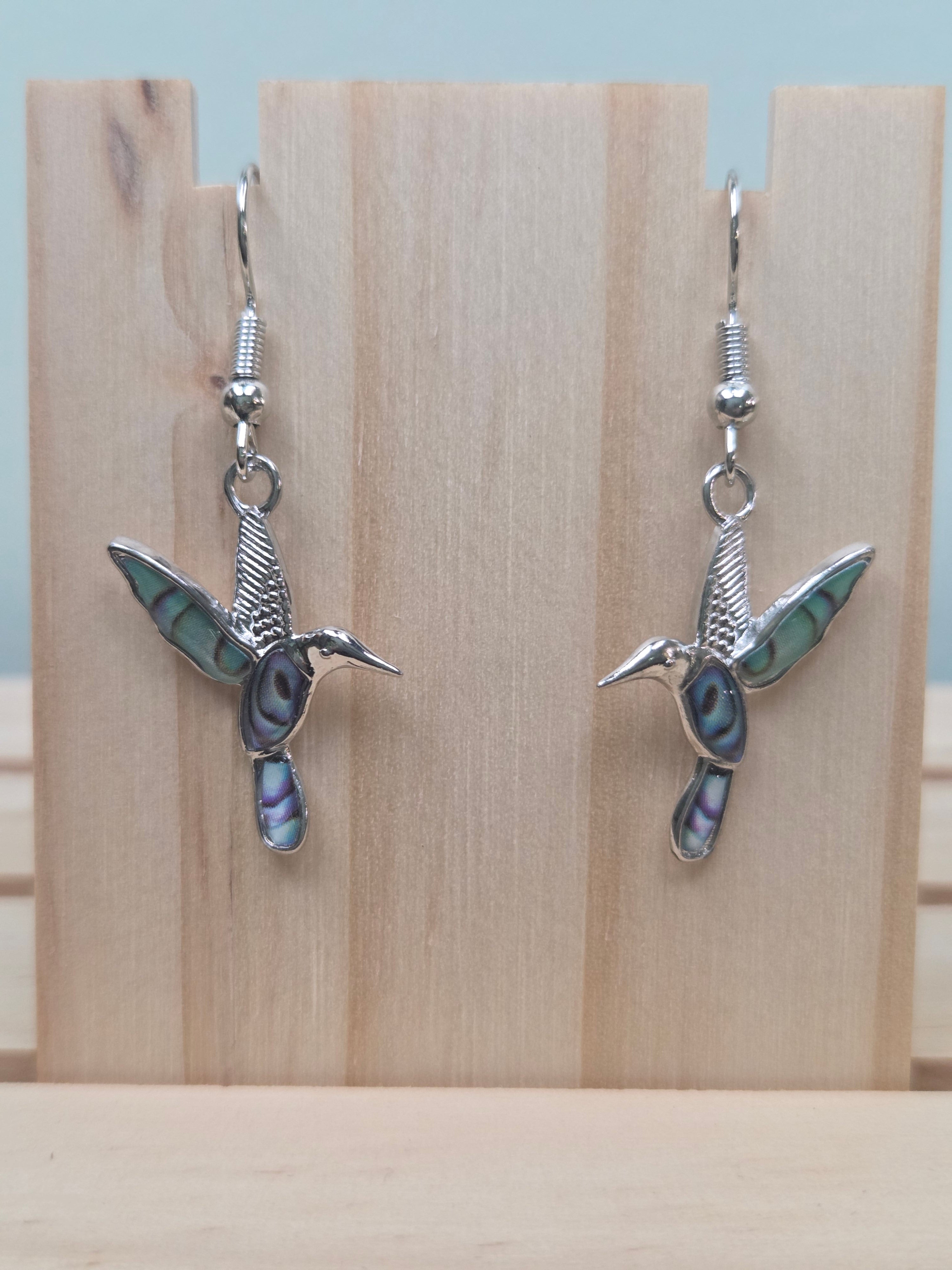 Abalone-style acrylic inlay hummingbird dangle earrings against ruler showing approximately 1 inch charm length