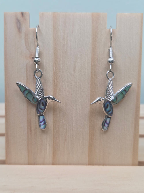 Abalone-style acrylic inlay hummingbird dangle earrings against ruler showing approximately 1 inch charm length