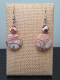 Crackle glass disc drop earrings with mottled glass accent bead, displayed on a wooden earring stand with ruler showing approximately 2 inch length