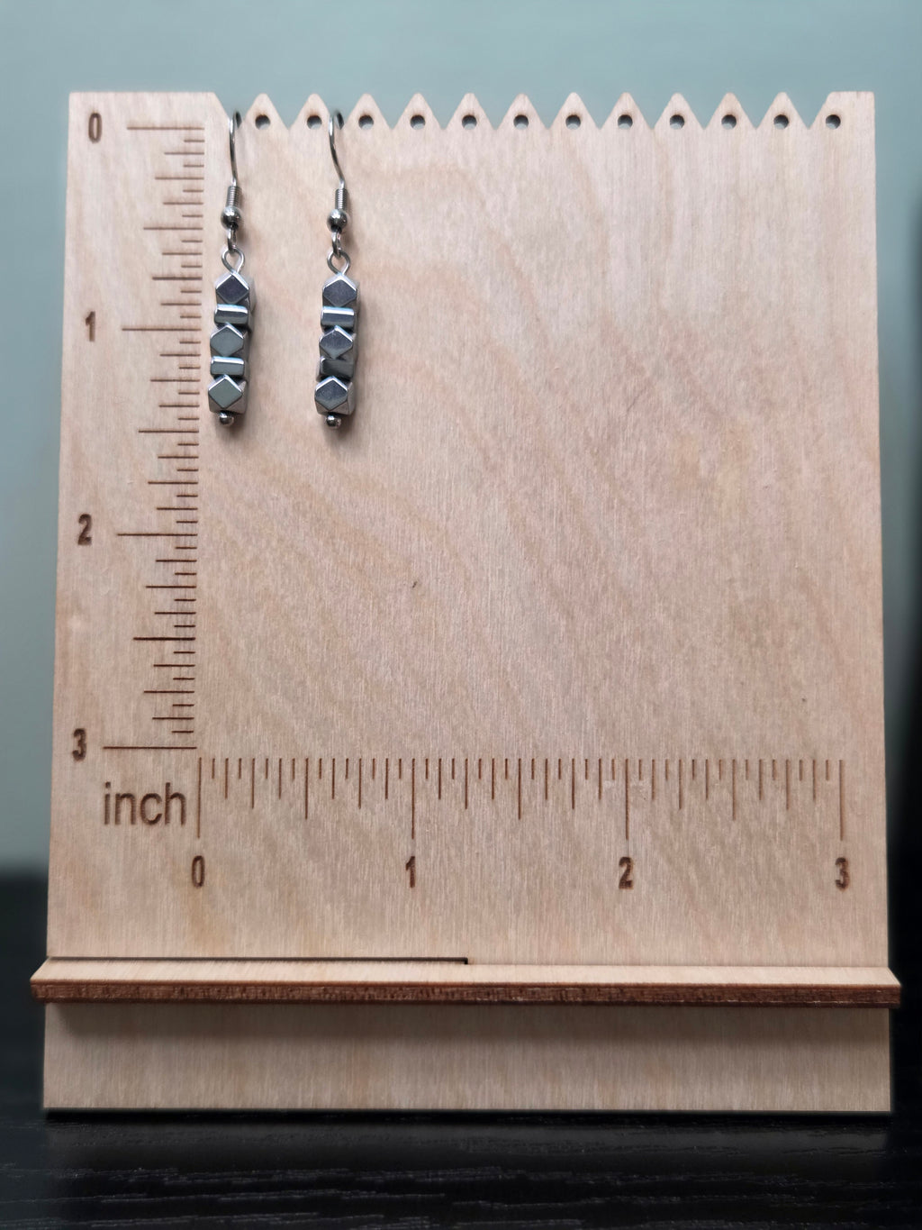 Close-up of five genuine faceted hematite beads stacked in each earring, showing gunmetal silver geometric facets
