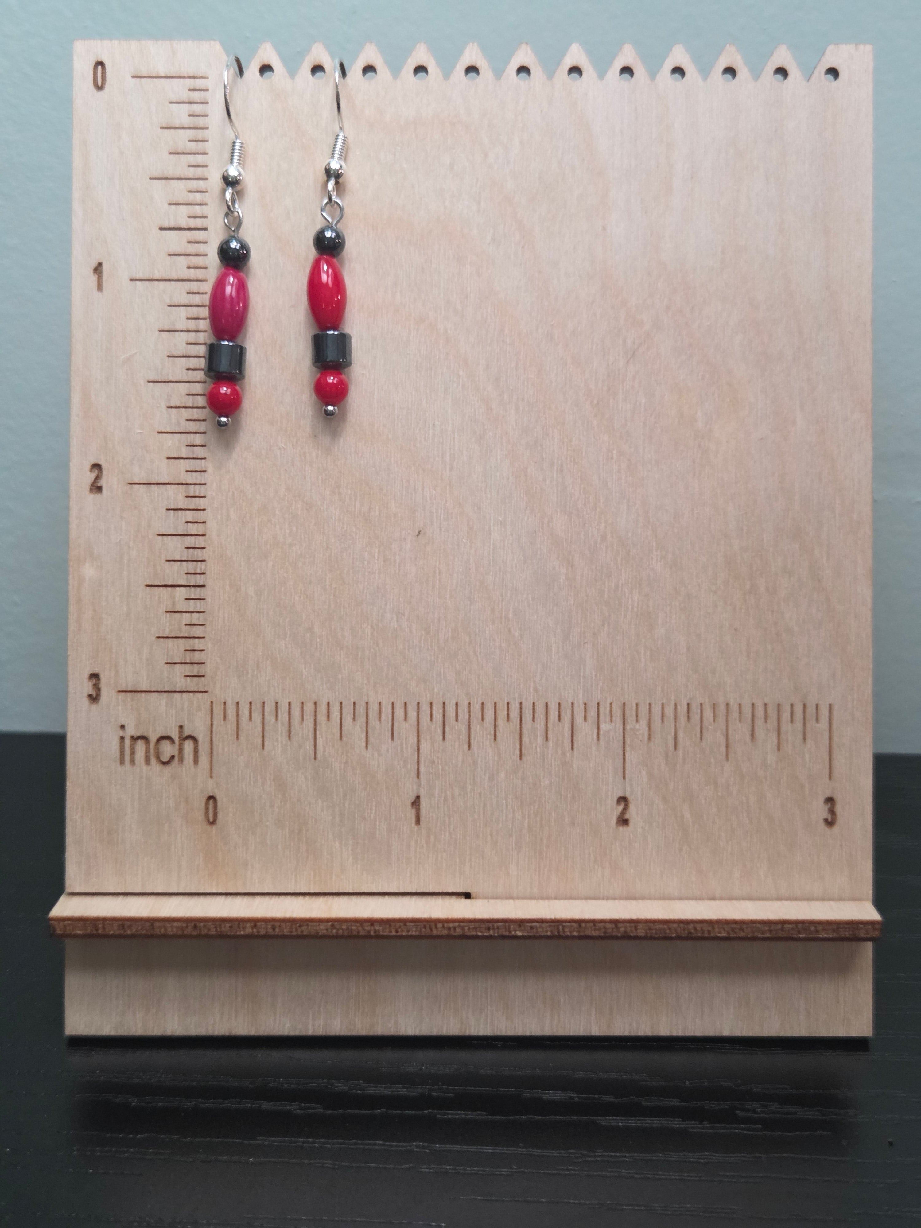 Hematite and coral stacked bead dangle earrings against ruler showing approximately 1.5 inch length