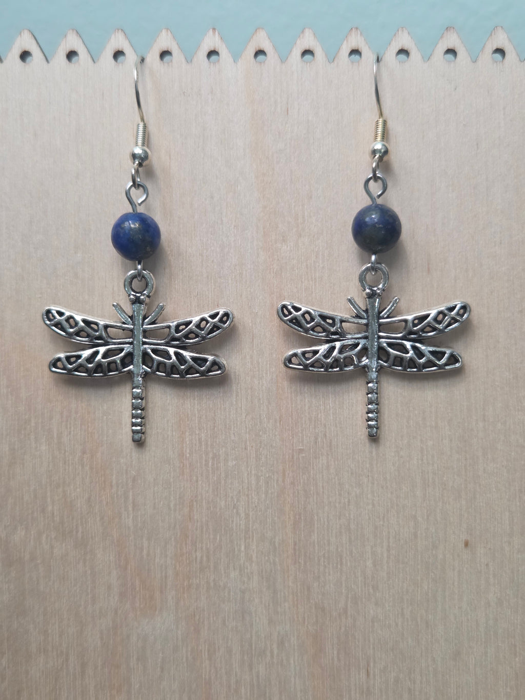 Dragonfly and sodalite drop earrings with antiqued silver-tone filigree dragonfly charm, displayed on a wooden earring stand with ruler showing approximately 2 inch length