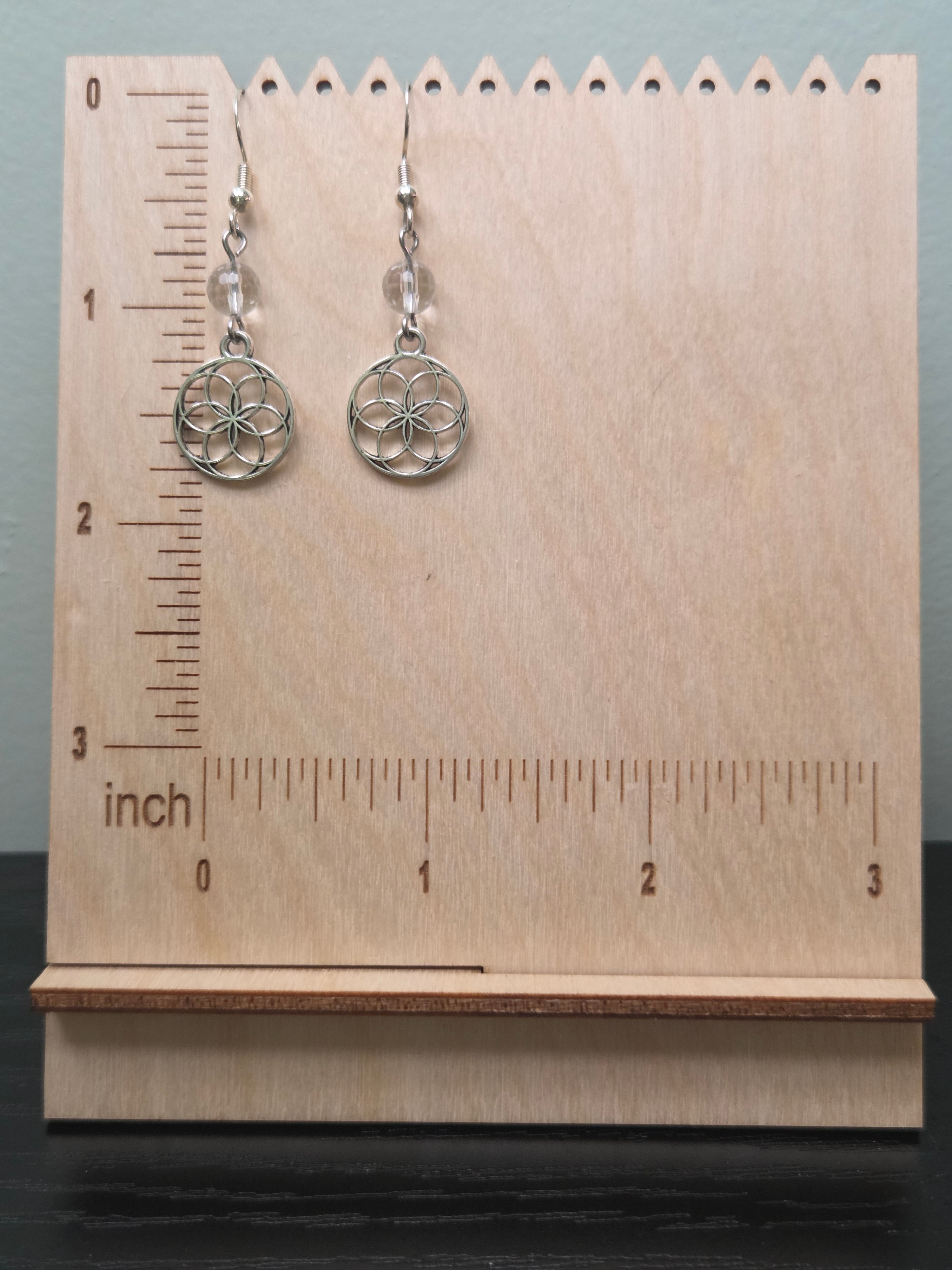 Small Seed of Life quartz dangle earrings against ruler showing approximately 1.75 inch length