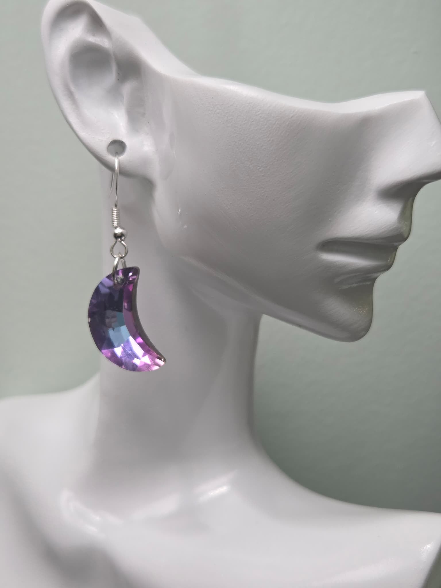 Deep purple lavender faceted crystal crescent moon earring shown on white ceramic ear display, side profile view